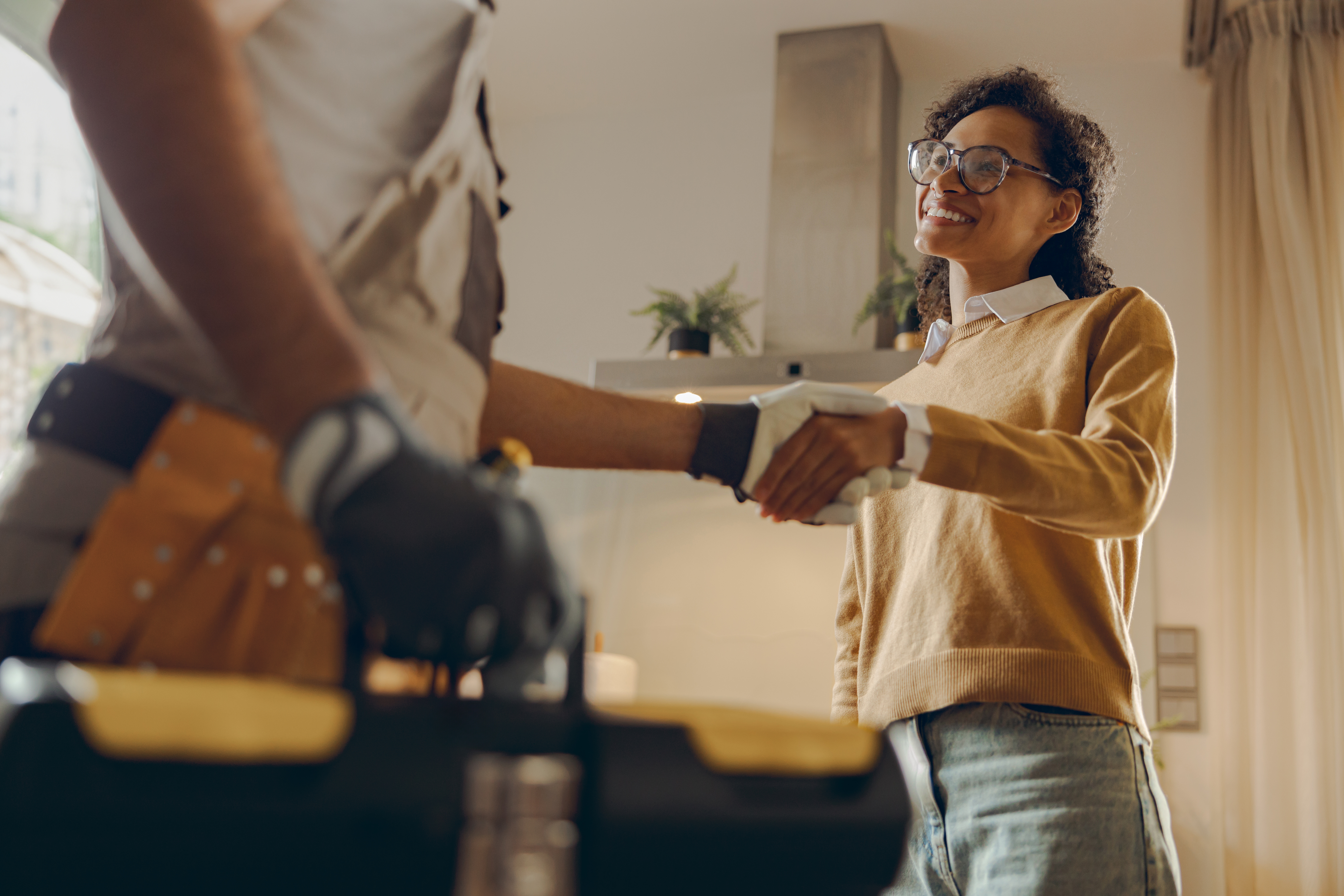 A service provider from WyattWorks in Cleveland, OH shaking hands with a homeowner after installing moen flo.