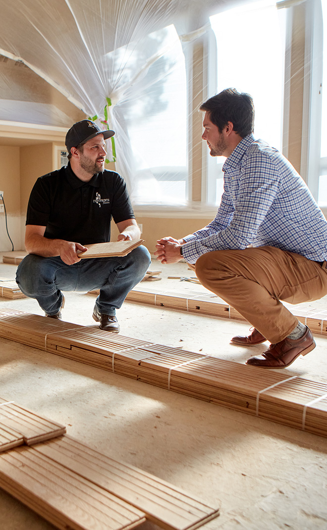 Two Footprints Floors Denver professionals installing flooring in a home for the fall season.