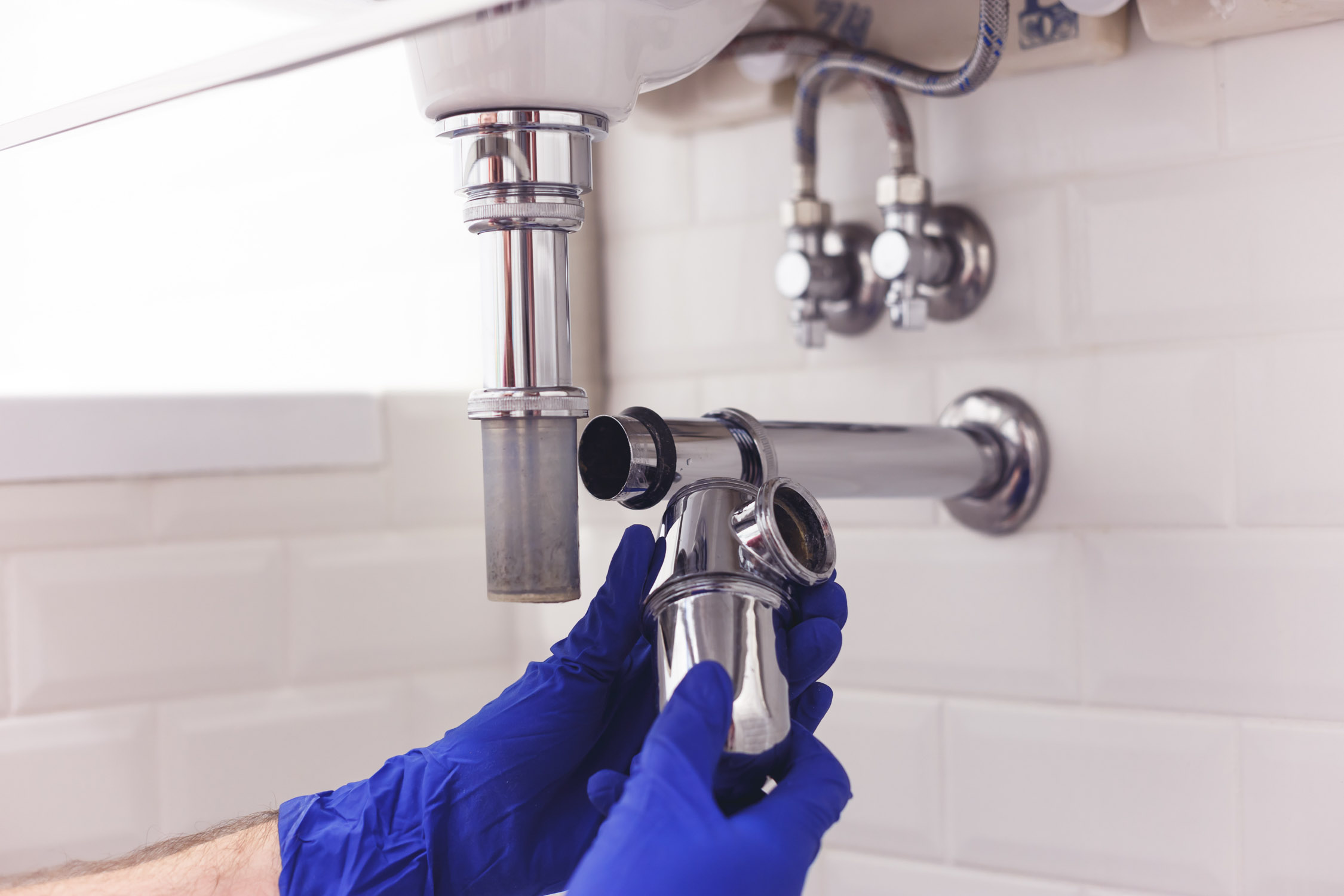 A WyattWorks service provider clearing a clogged drain as part of our residential plumbing services.