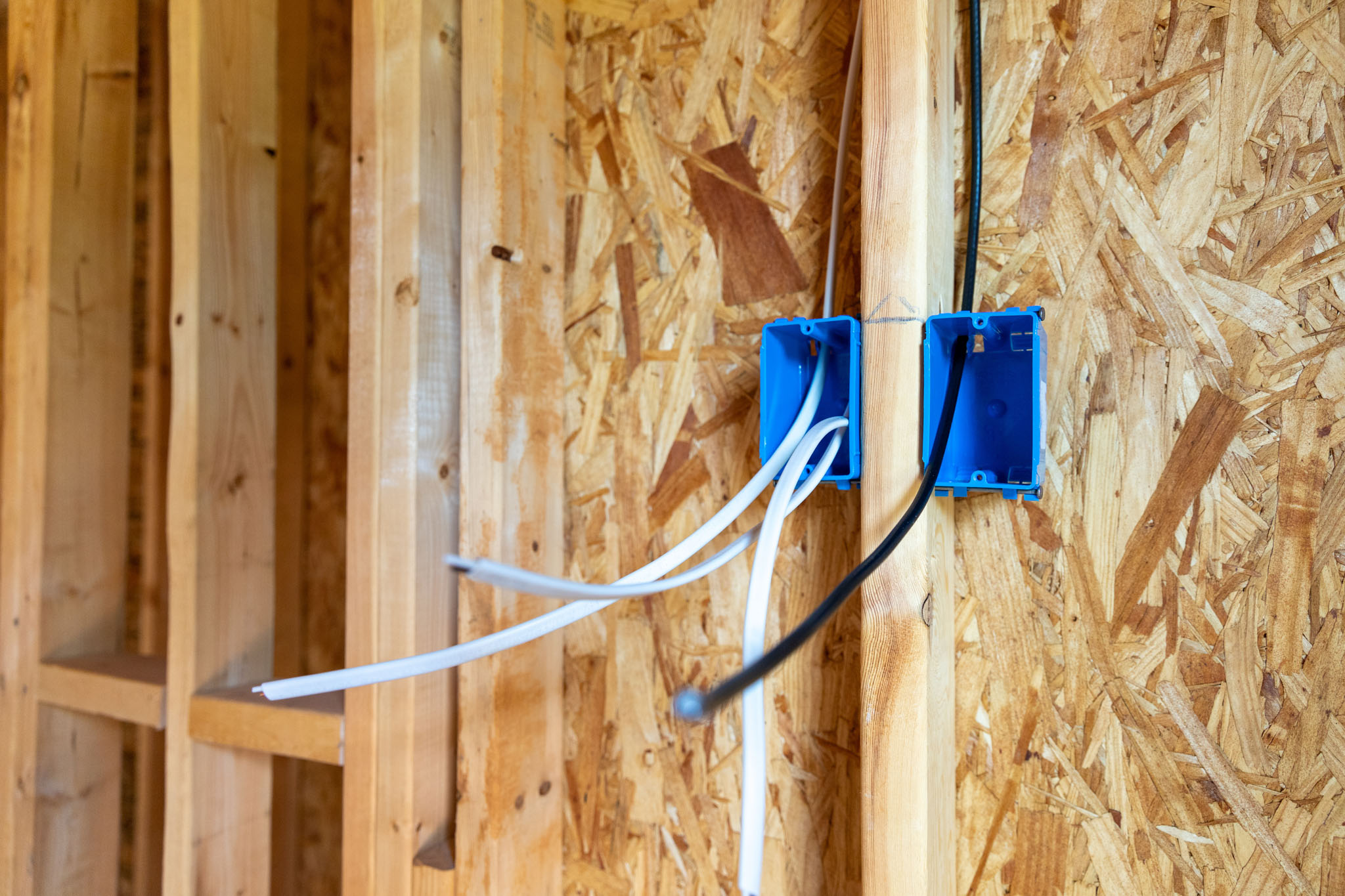 An electrician working on installing electrical switches in a new home.