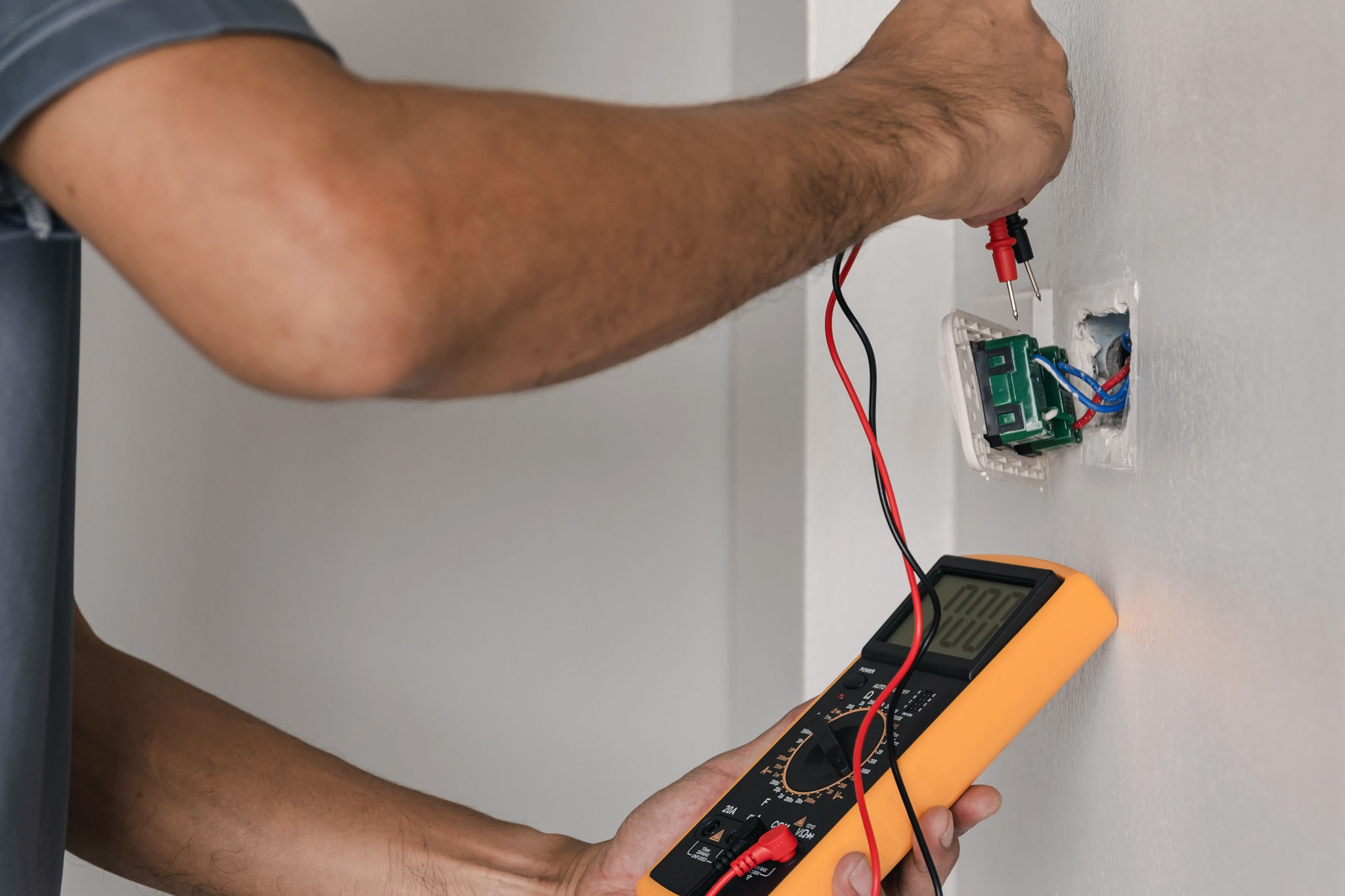 An outlet being inspected by an electrician - WyattWorks offers excellent electrical inspection in Ohio & North Carolina.