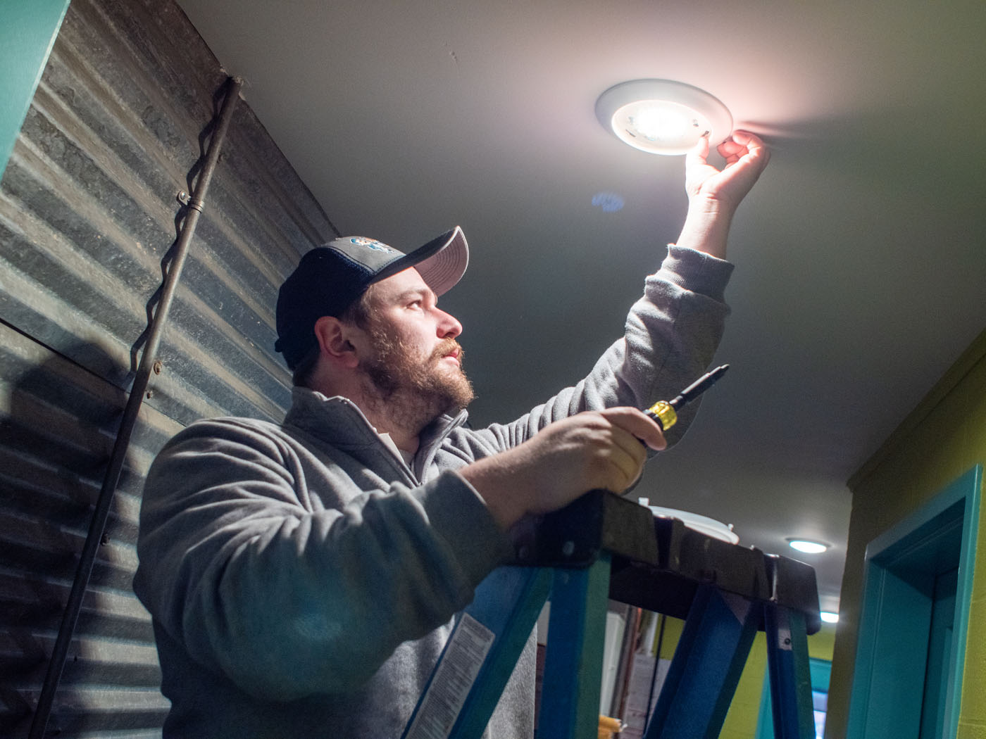 A WyattWorks local electrician in Ohio & North Carolina, {fran_state_abbrev} working on a lighting fixture.
