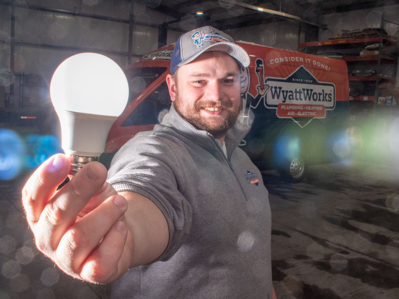 A team member holding a lightbulb - if you're looking for one of the best electricians in Ohio & North Carolina, {fran_state_abbrev}, choose WyattWorks.