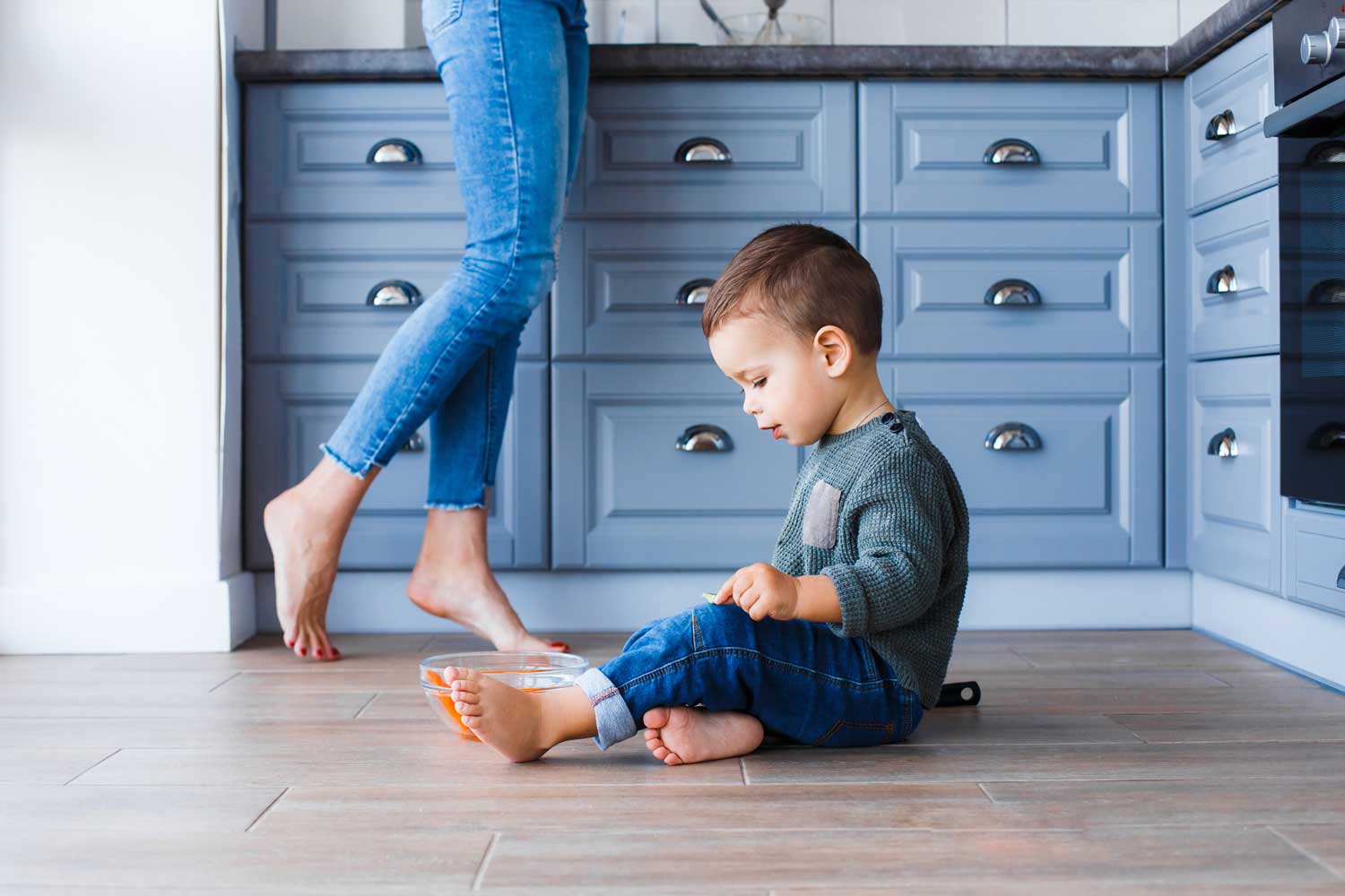 Mom and child barefoot on hardwood to protect from scrapes - learn more with Footprints Floors in Durham / Chapel Hill.