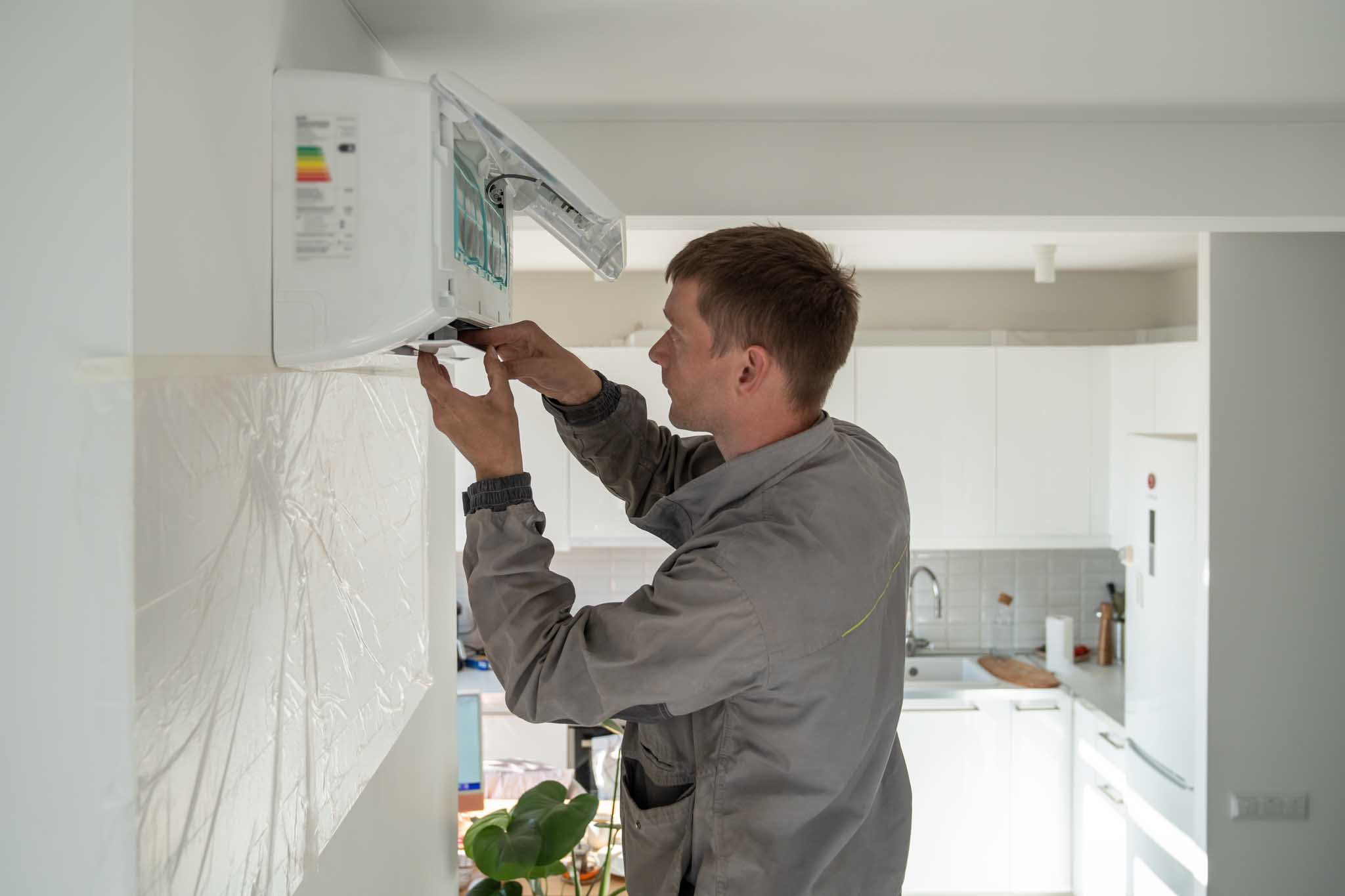An HVAC tecnician installing a ductless system - contact WyattWorks today for professional HVAC services in Cleveland, OH.