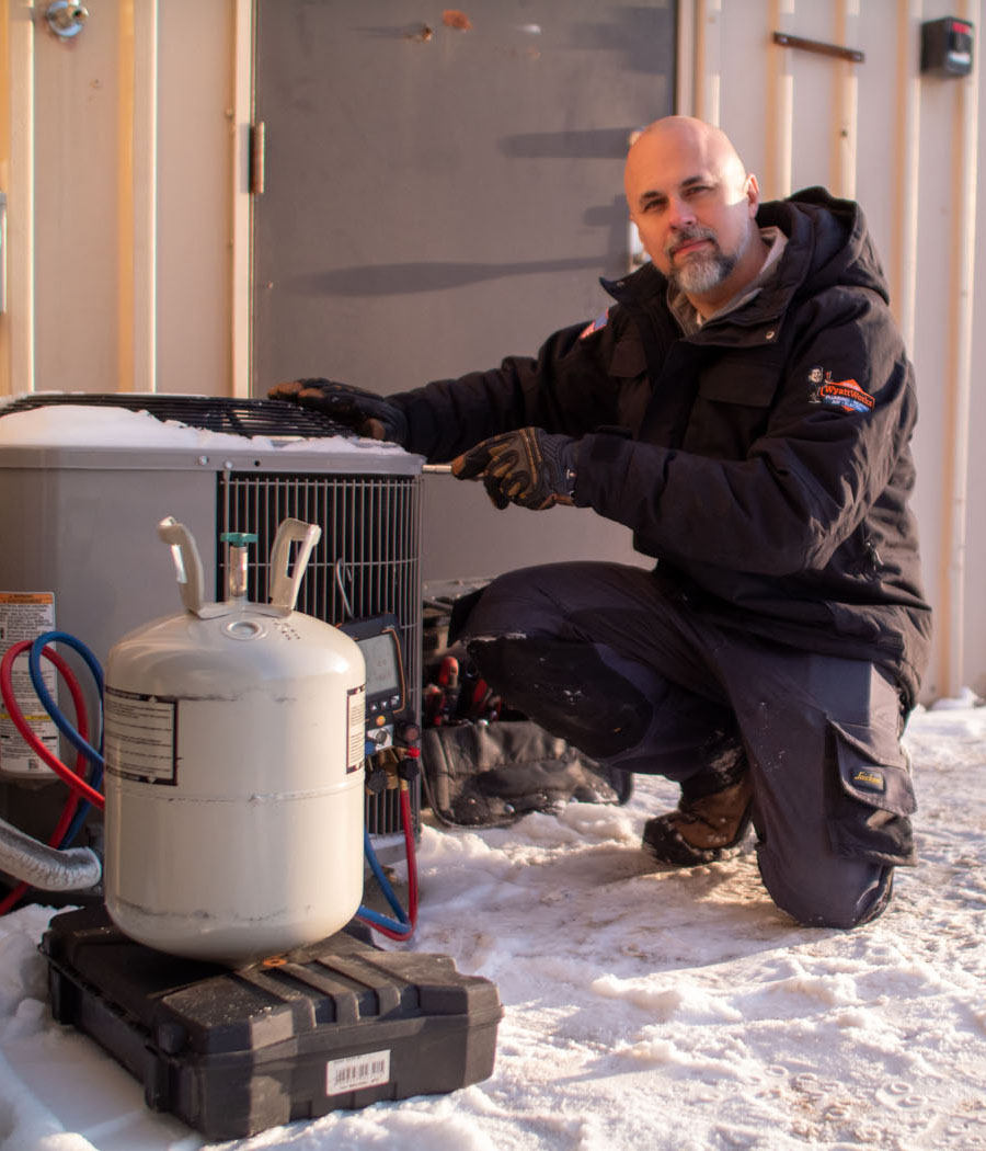 A WyattWorks expert examining an air conditioning unit.