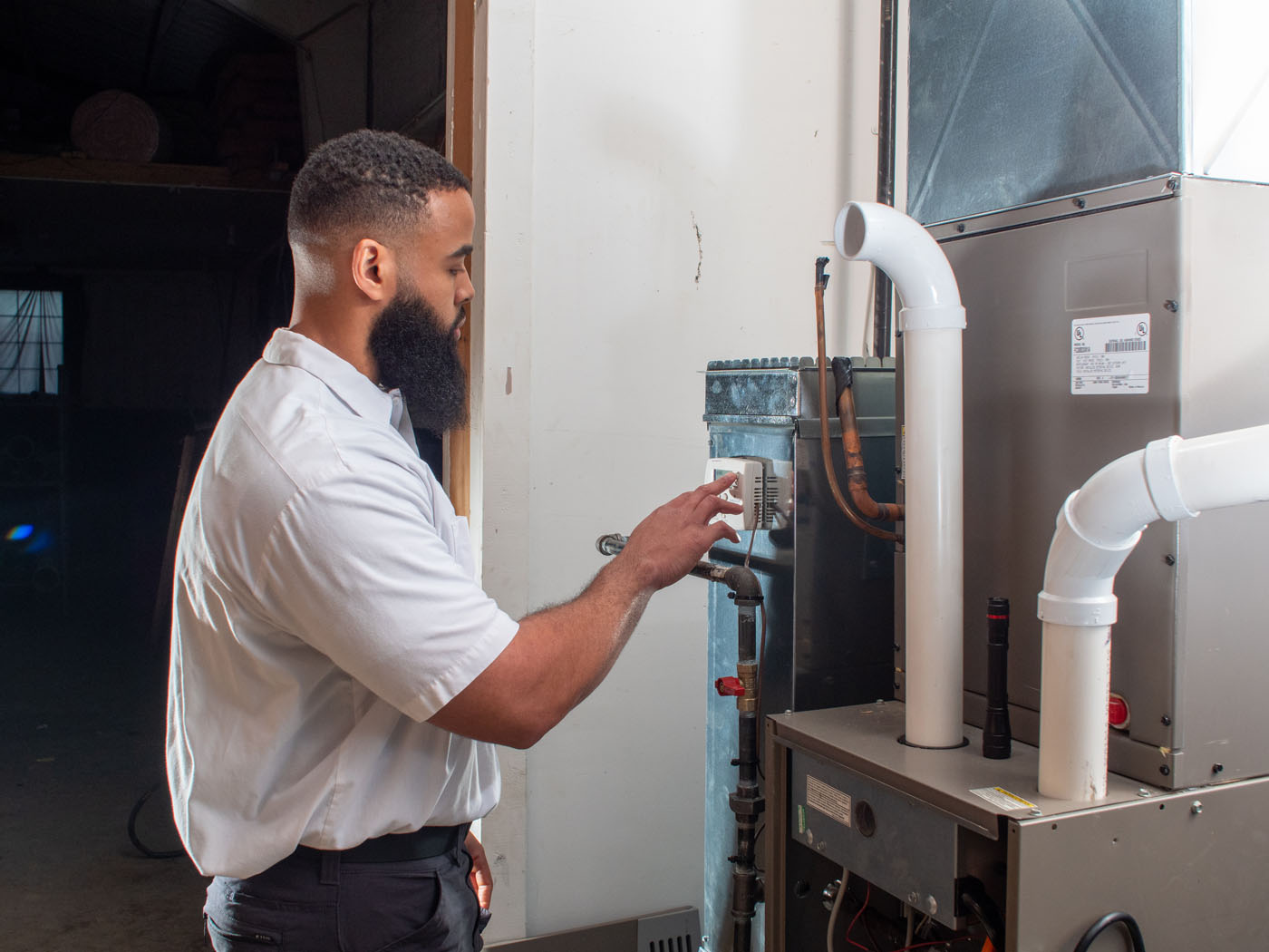 A WyattWorks professional servicing a furnace in Ohio & North Carolina, {fran_state_abbrev}.