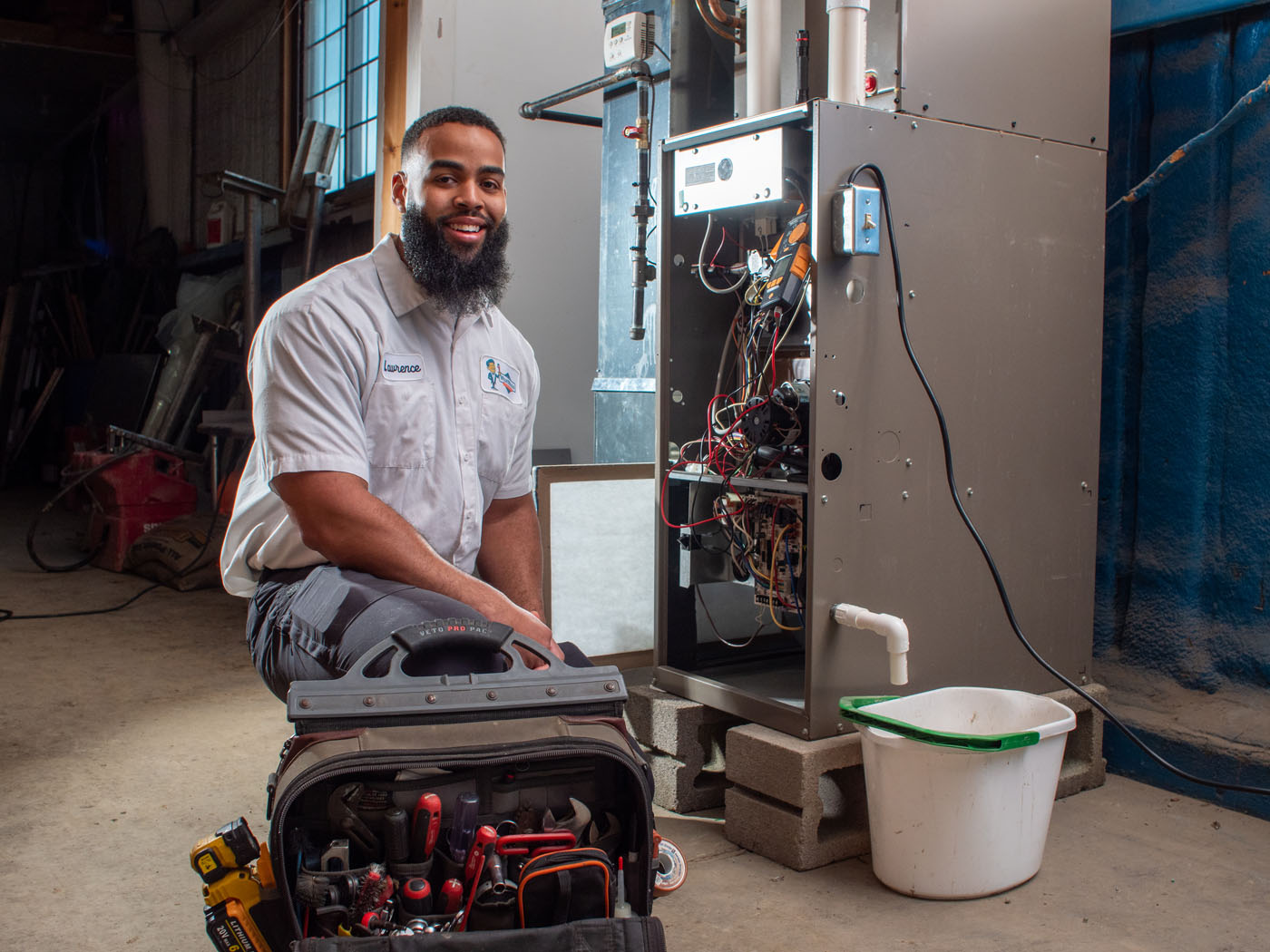 One of WyattWorks heating contractors in Ohio & North Carolina, {fran_state_abbrev} posing in front of a furnace system.