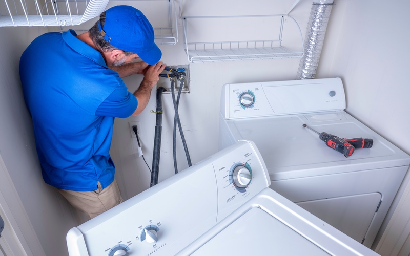 Our WyattWorks Plumbing plumbing contractors working on a washing machine.