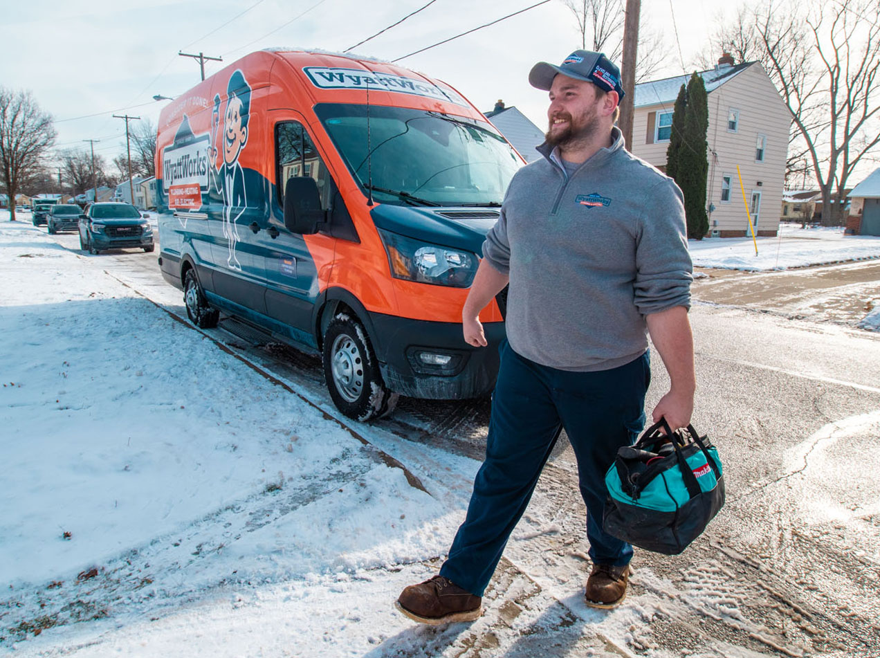 A WyattWorks Plumbing contractor walking from his van to a home - call WyattWorks for an emergency plumber in Ohio & North Carolina, {fran_state_abbrev}.